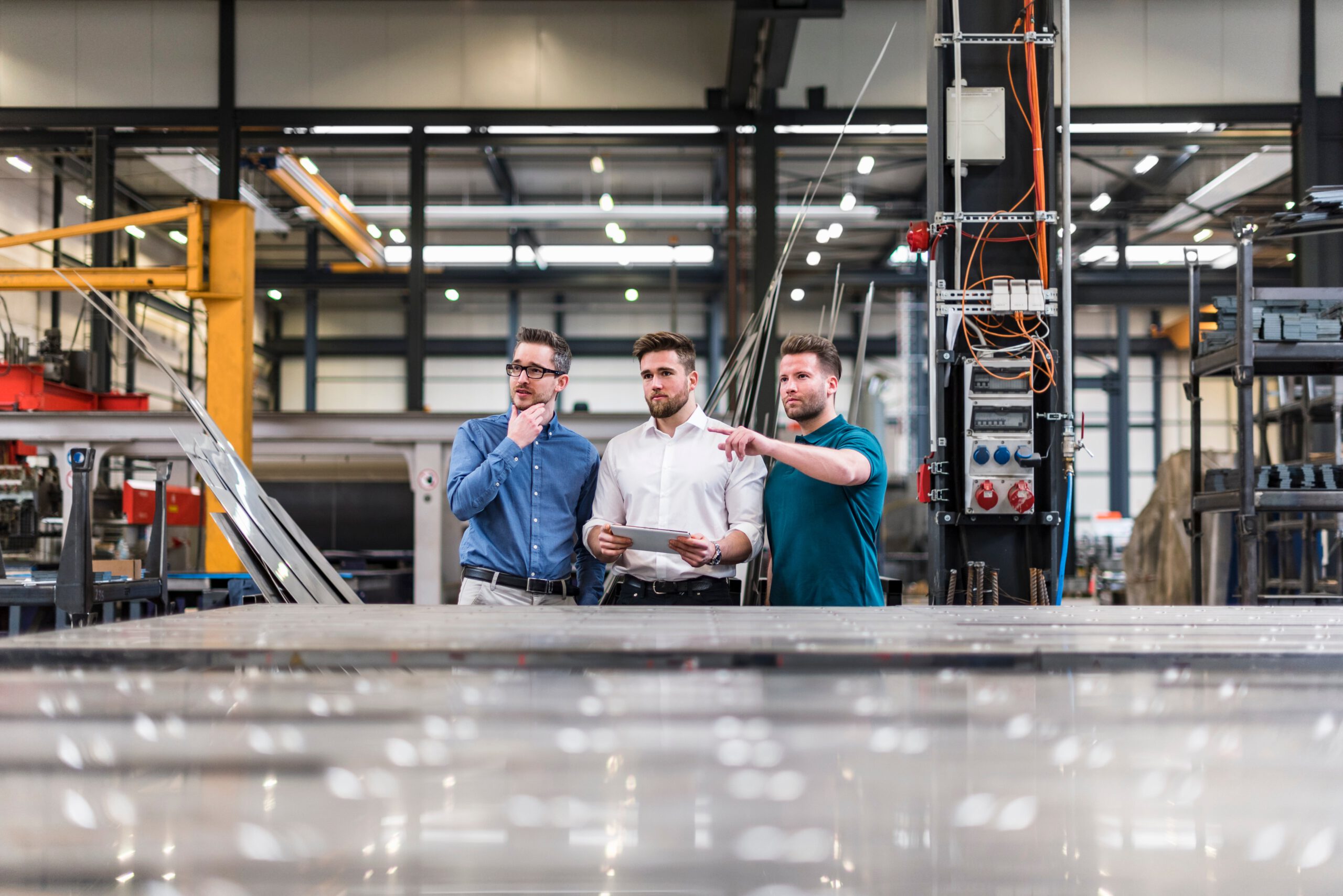 three-men-sharing-tablet-on-factory-shop-floor-2022-12-16-22-09-31-utc